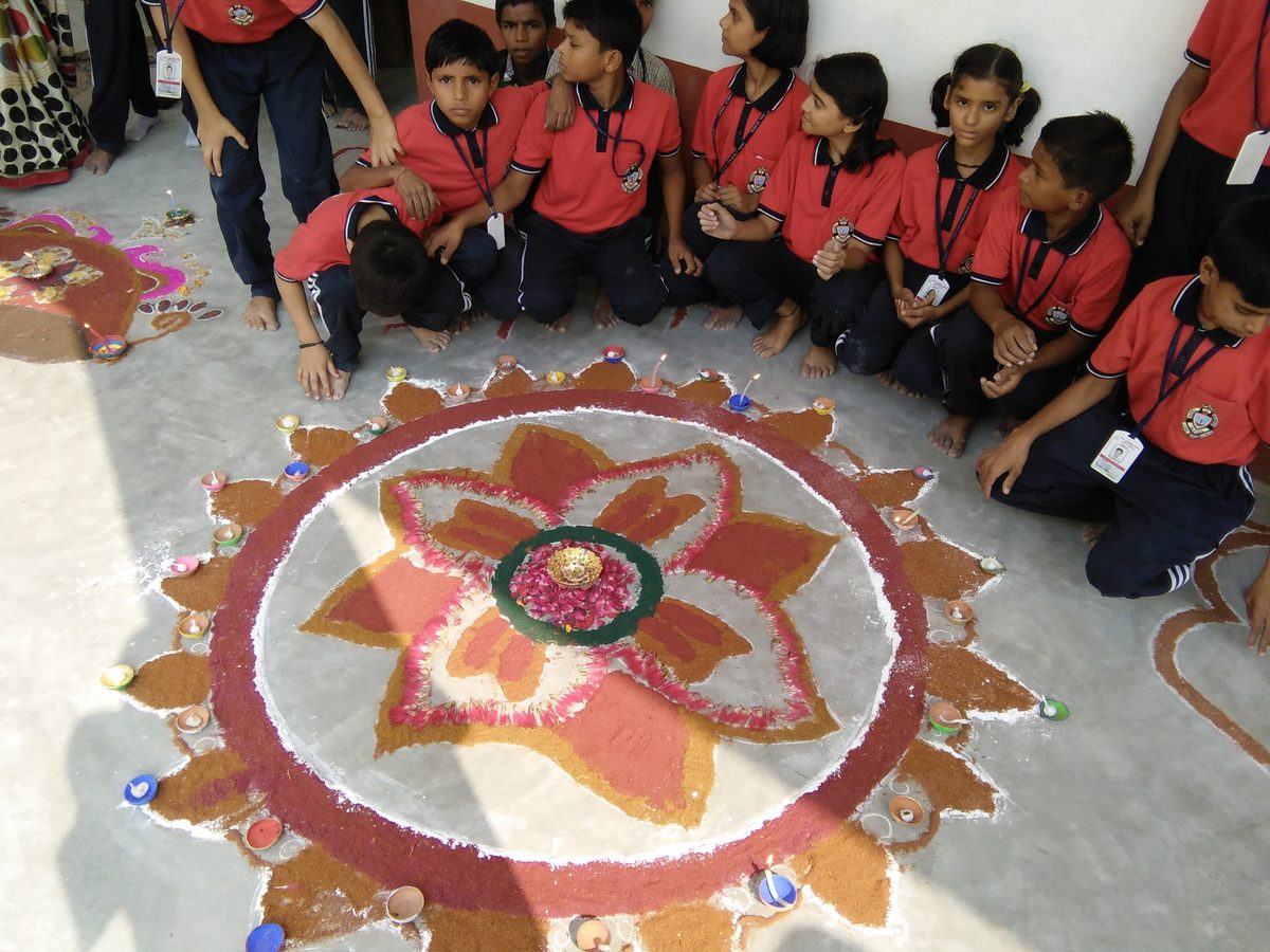 Students with a rangoli art display